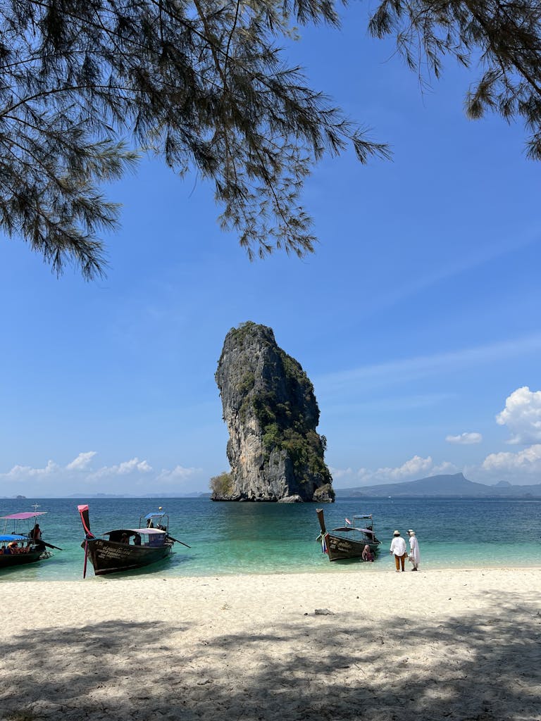 Beautiful beach scene with a limestone karst at Ao Nang, Krabi, Thailand under a clear blue sky.