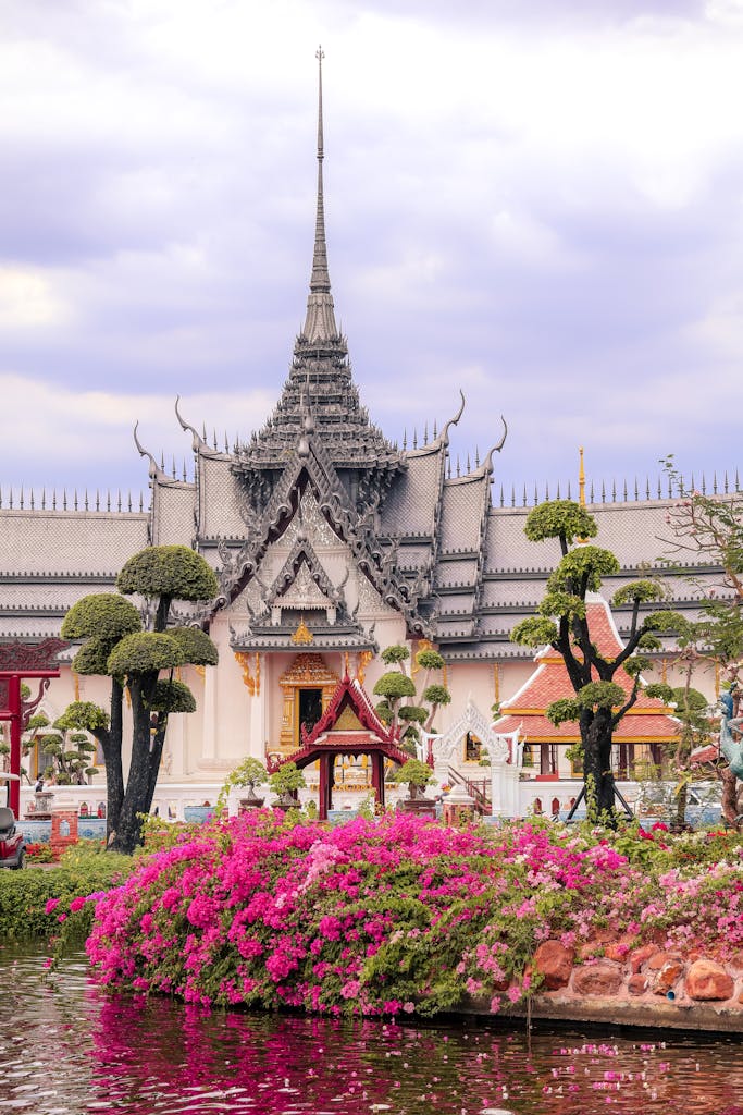 Beautiful Thai temple surrounded by garden blooms in Samut Prakan, Thailand, captured during the day.
