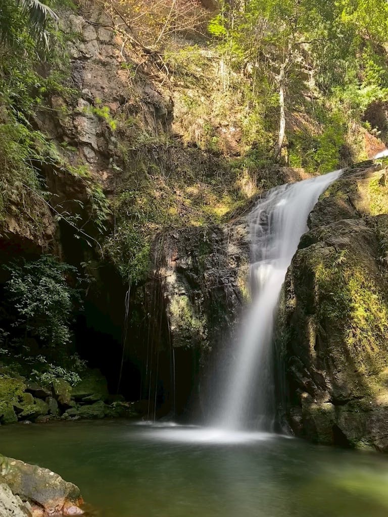 Beautiful waterfall amidst lush greenery in Krabi, Thailand, showcasing nature's serenity.