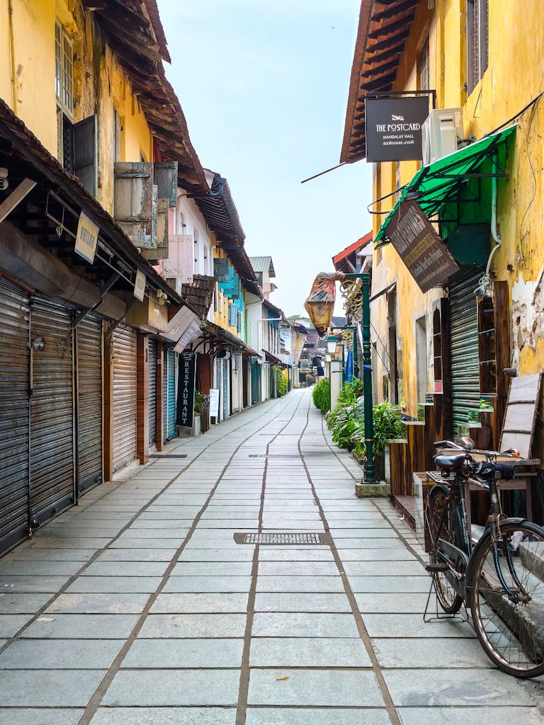 Colorful empty street of Fort Kochi, Kerala, India with traditional architecture and vintage bicycle.