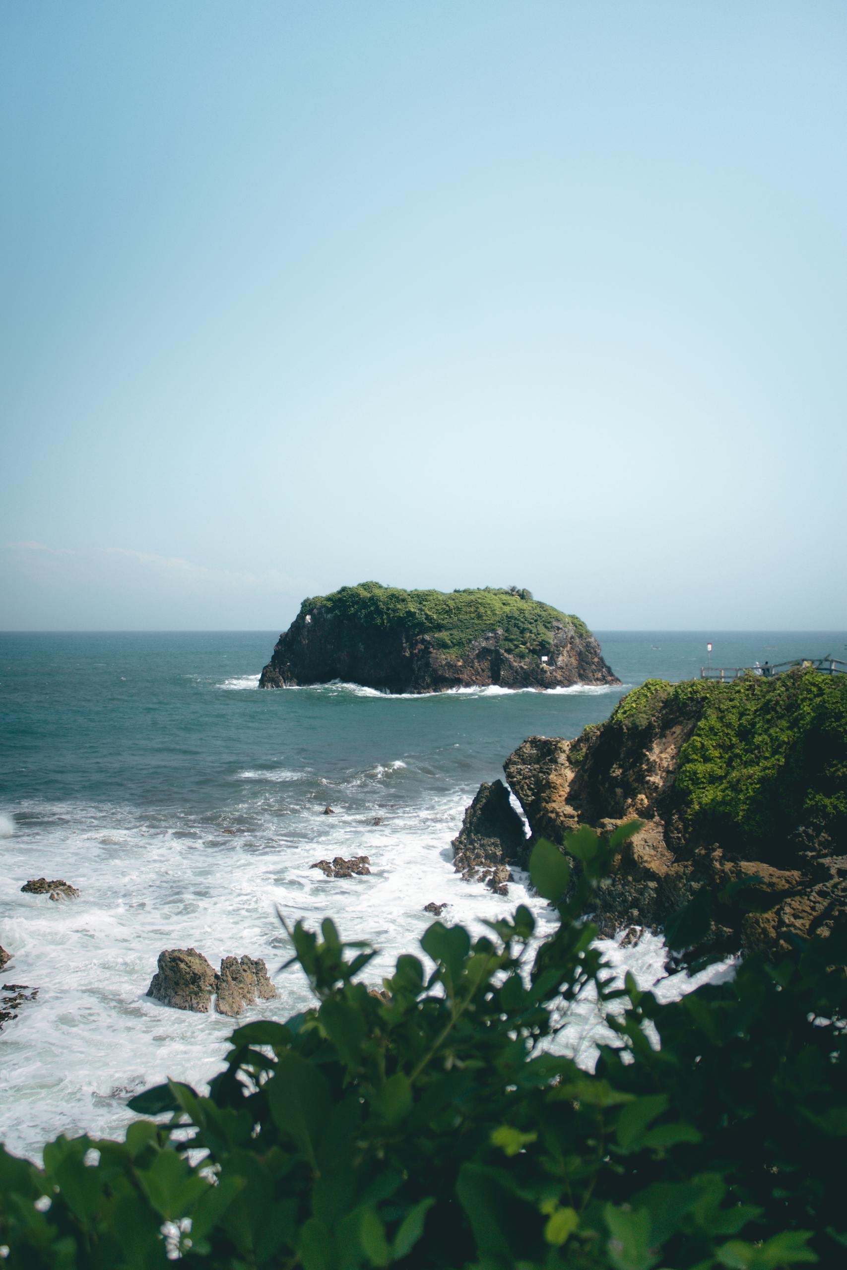 Explore the tranquil beaches and lush cliffs of Tasikmalaya, West Java, Indonesia, captured beautifully in sunlight.