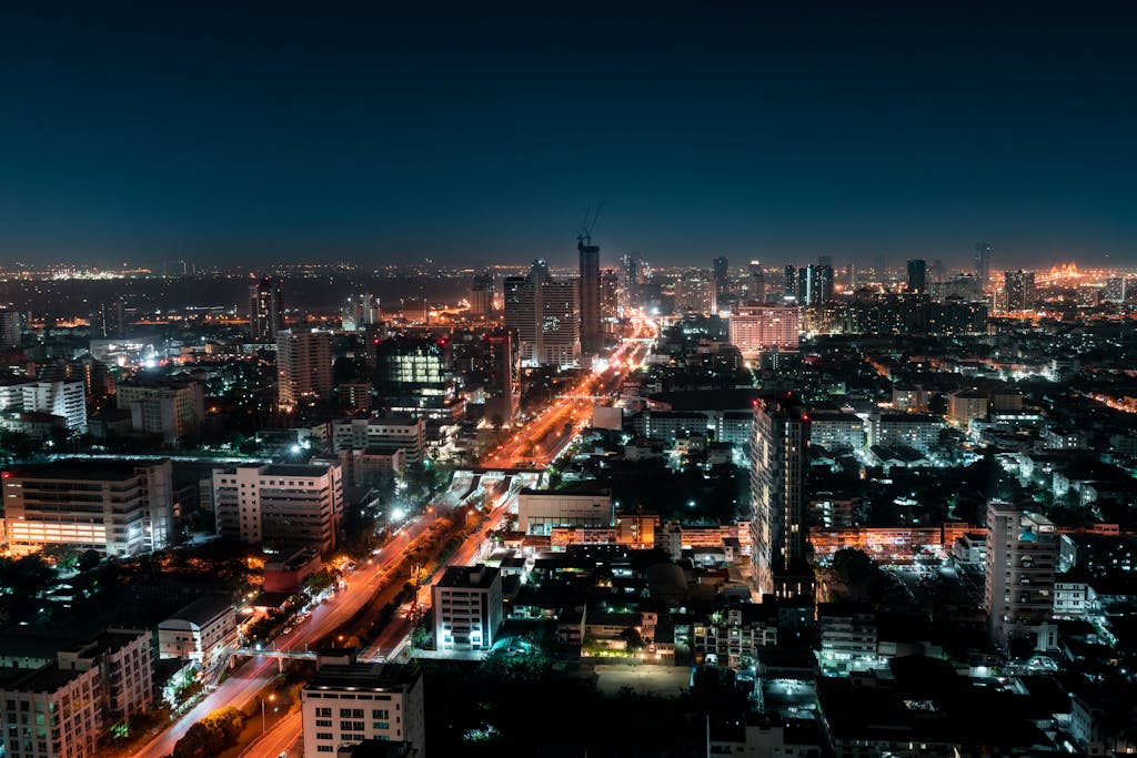 Explore the vibrant skyline of Bangkok with its illuminated skyscrapers and bustling streets captured at night.