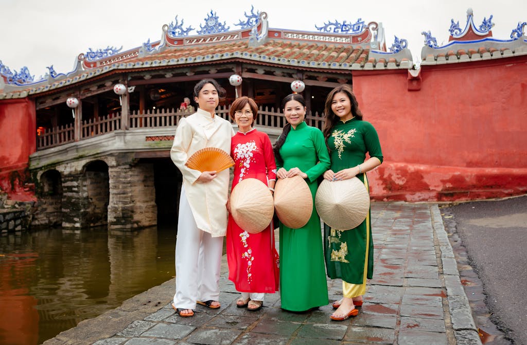 Group in traditional Vietnamese clothing by Hội An's iconic Japanese Bridge.