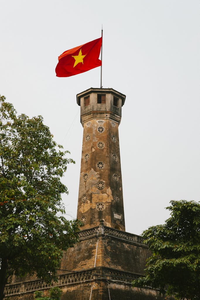 Historic Hanoi Flag Tower with Vietnamese flag waving, iconic landmark in Vietnam's capital.