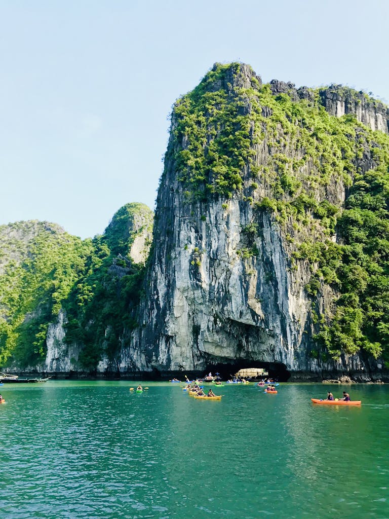 Kayakers paddling through the scenic cliffs of Hạ Long Bay, Vietnam.