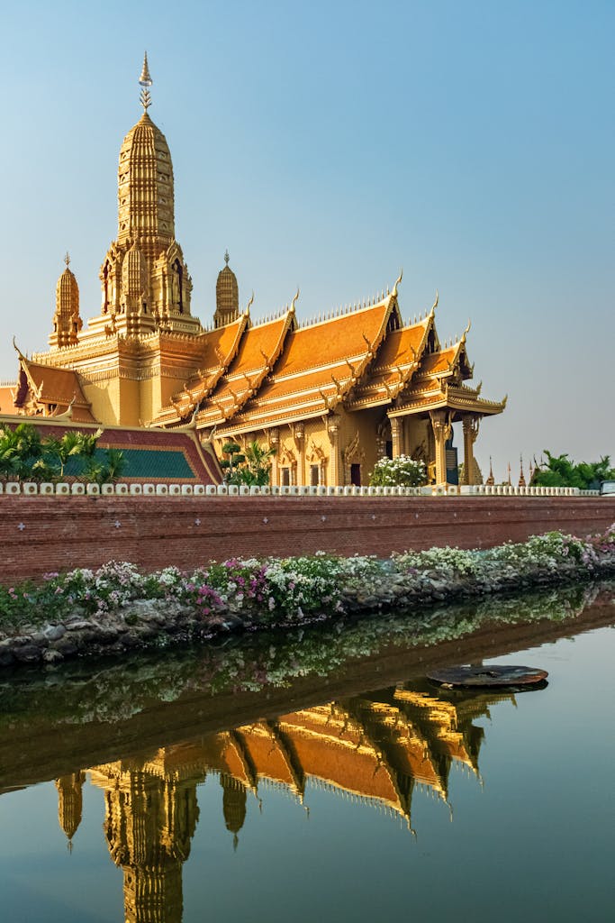 Majestic golden temple reflecting in water, showcasing traditional Thai architecture in Bangkok.