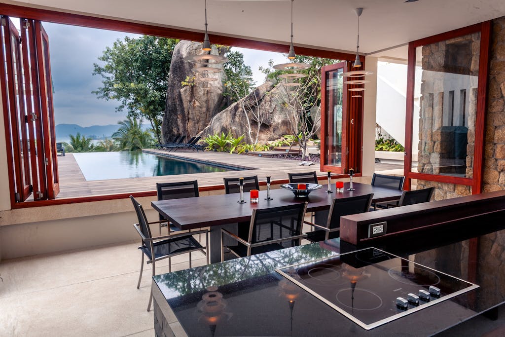 Modern villa with open dining area and infinity pool, set in Thailand.