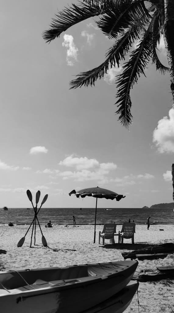 Relax on a tranquil Phuket beach with palm trees, chairs, and a sea view.