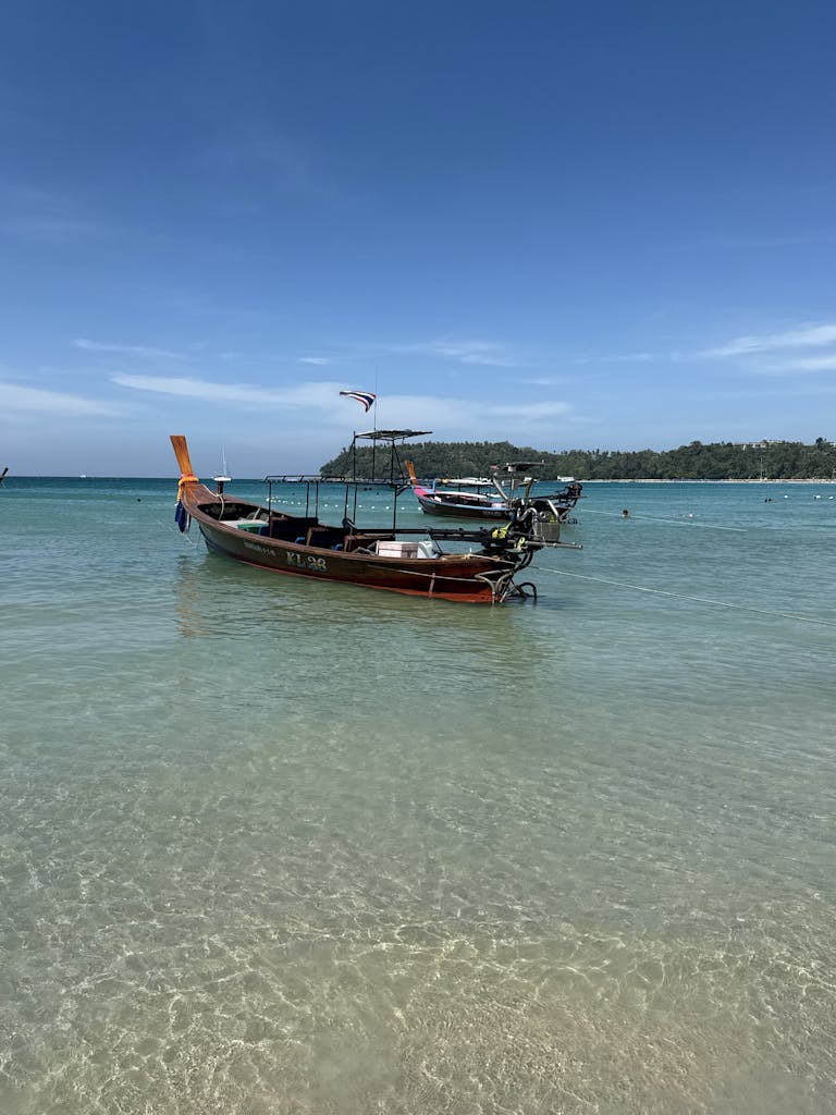 Serene view of longtail boats anchored in clear waters at Phuket, Thailand
