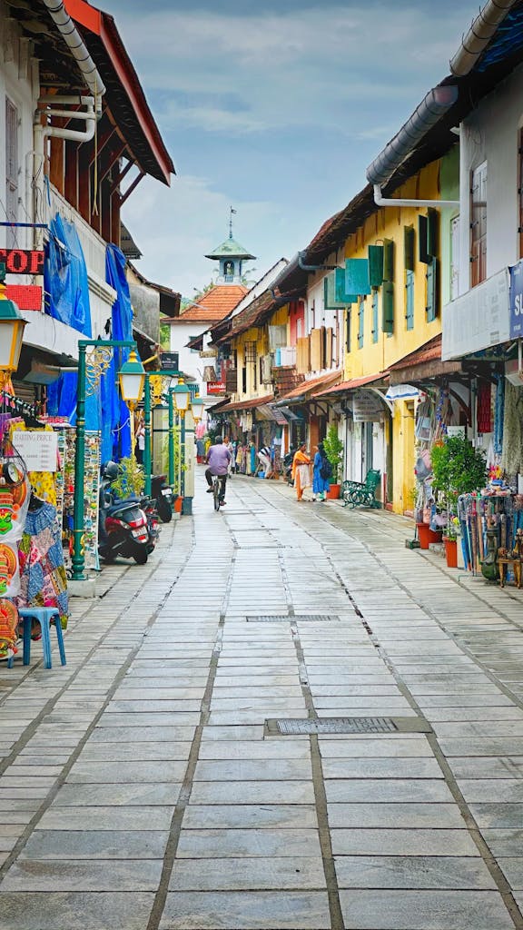 Vibrant urban street in Kochi, Kerala with colorful facades and bustling life.