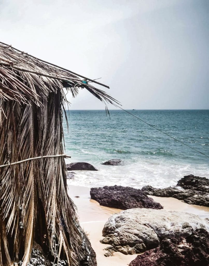 A rustic beach hut on the rocky shores of Kola Beach in Goa, India.