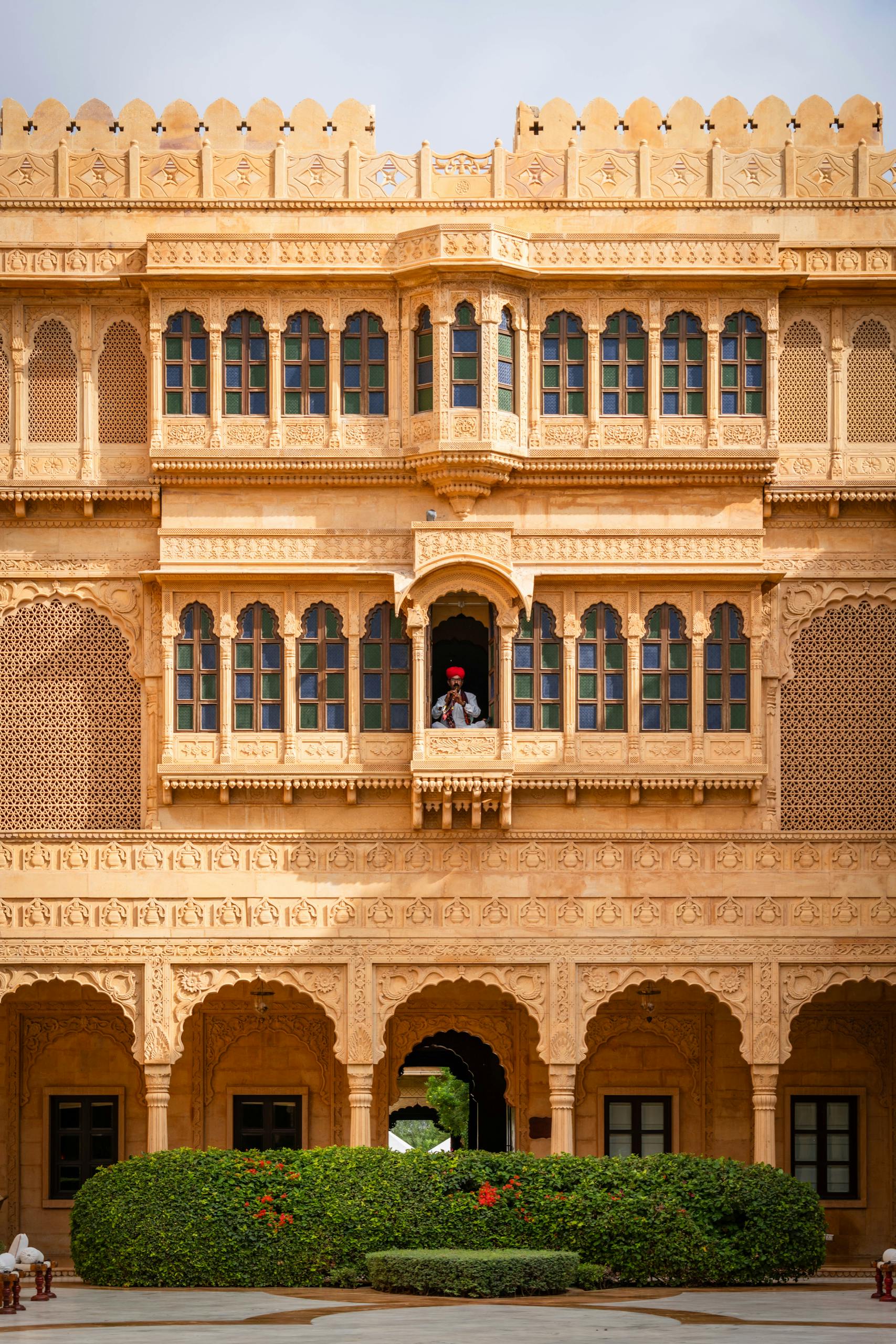 A traditional flute player performs in a jharokha at Suryagarh Palace, Jaisalmer.