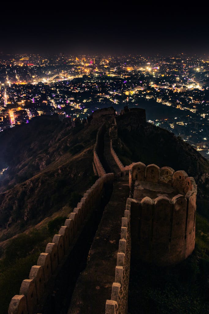 Aerial view of Nahargarh Fort with Jaipur city illuminated at night, showcasing its historic beauty.