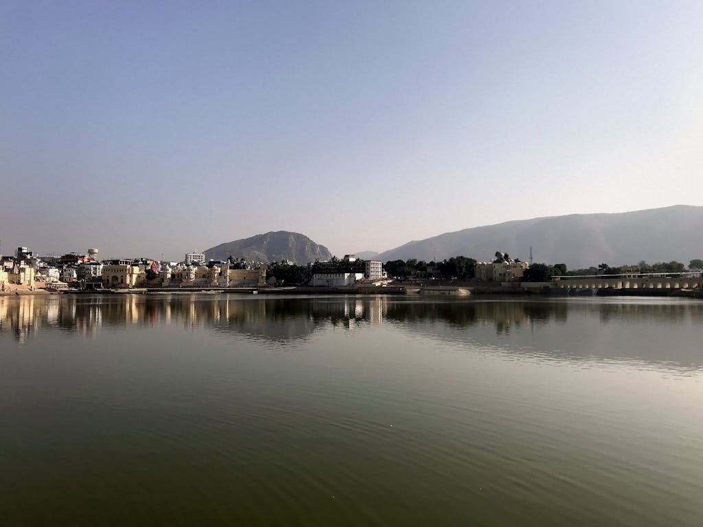 Beautiful morning view of Pushkar Lake with cityscape and mountains in India.