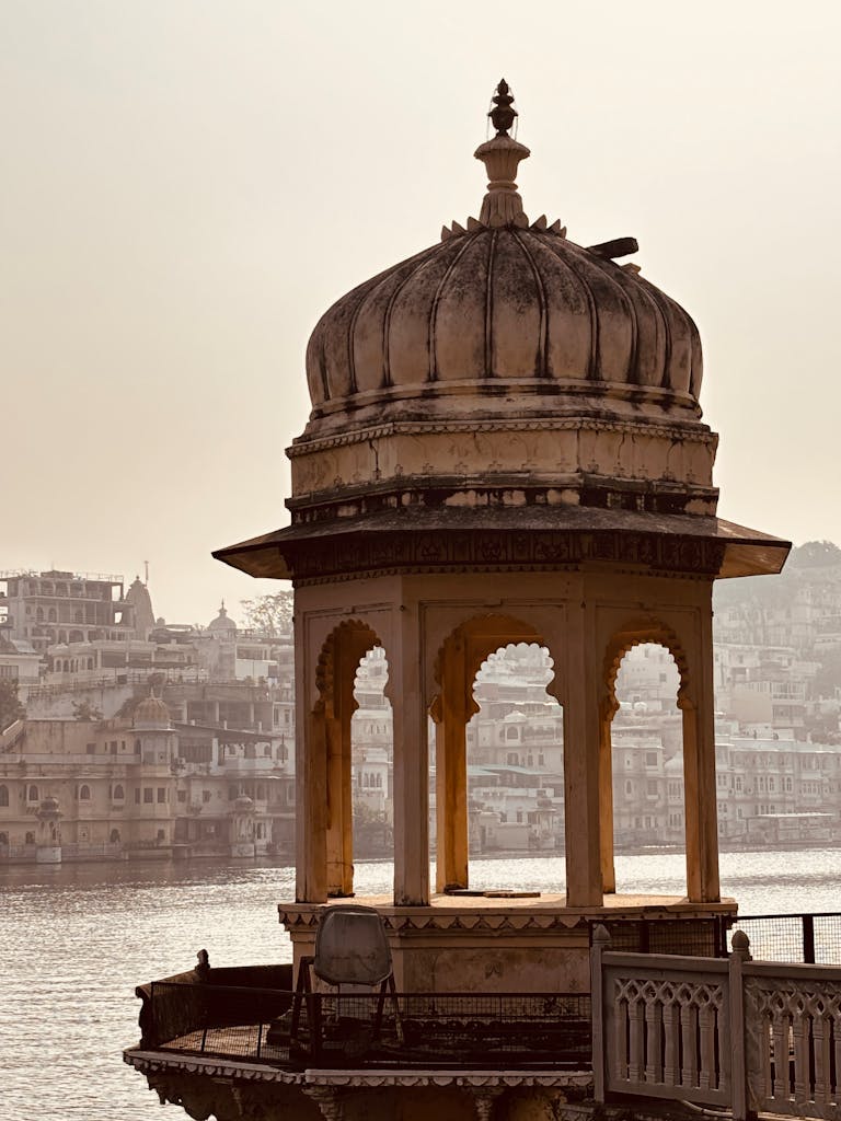 Historic pavilion with intricate architecture against Udaipur's scenic backdrop.