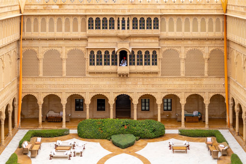 Luxurious sandstone courtyard with intricate carvings in Jaisalmer's heritage Suryagarh Palace.