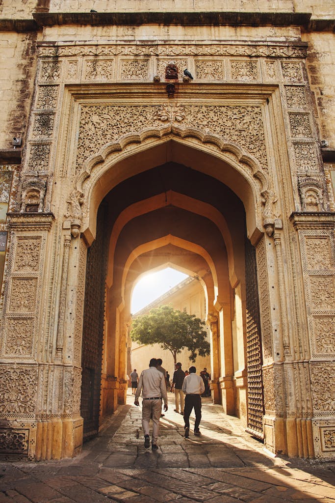 Visitors passing through an intricate archway in Jodhpur, India, capturing historic architectural beauty.
